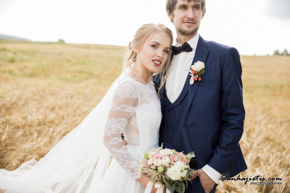 Kāzu fotogrāfija graudu pļavā